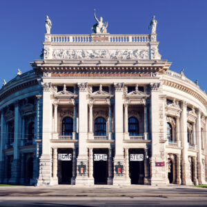 Vista frontale del Burgtheater sulla Ringstrasse di Vienna con le ali curve e le colonne.