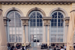 Tall arched windows and stone columns at the entrance of Café Gloriette.