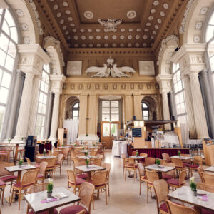 Grande salle du Café Gloriette avec colonnes blanches et larges fenêtres sur Schönbrunn.