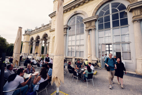 Guests seated at outdoor tables on the terrace of Café Gloriette at Schönbrunn.