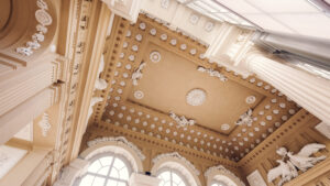 Close-up of the ornate ceiling with medallions and sculptures inside Café Gloriette.