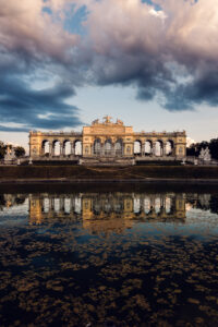 Gloriette reflected in still water at Schönbrunn Palace.