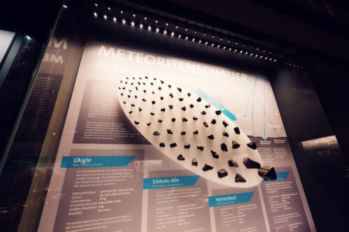 Meteorito rocoso en el Museo de Historia Natural de Viena con especímenes de condrita en la colección geológica.