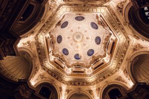 Interior de la gran cúpula central del Museo de Historia Natural de Viena con frescos en el techo y detalles dorados.