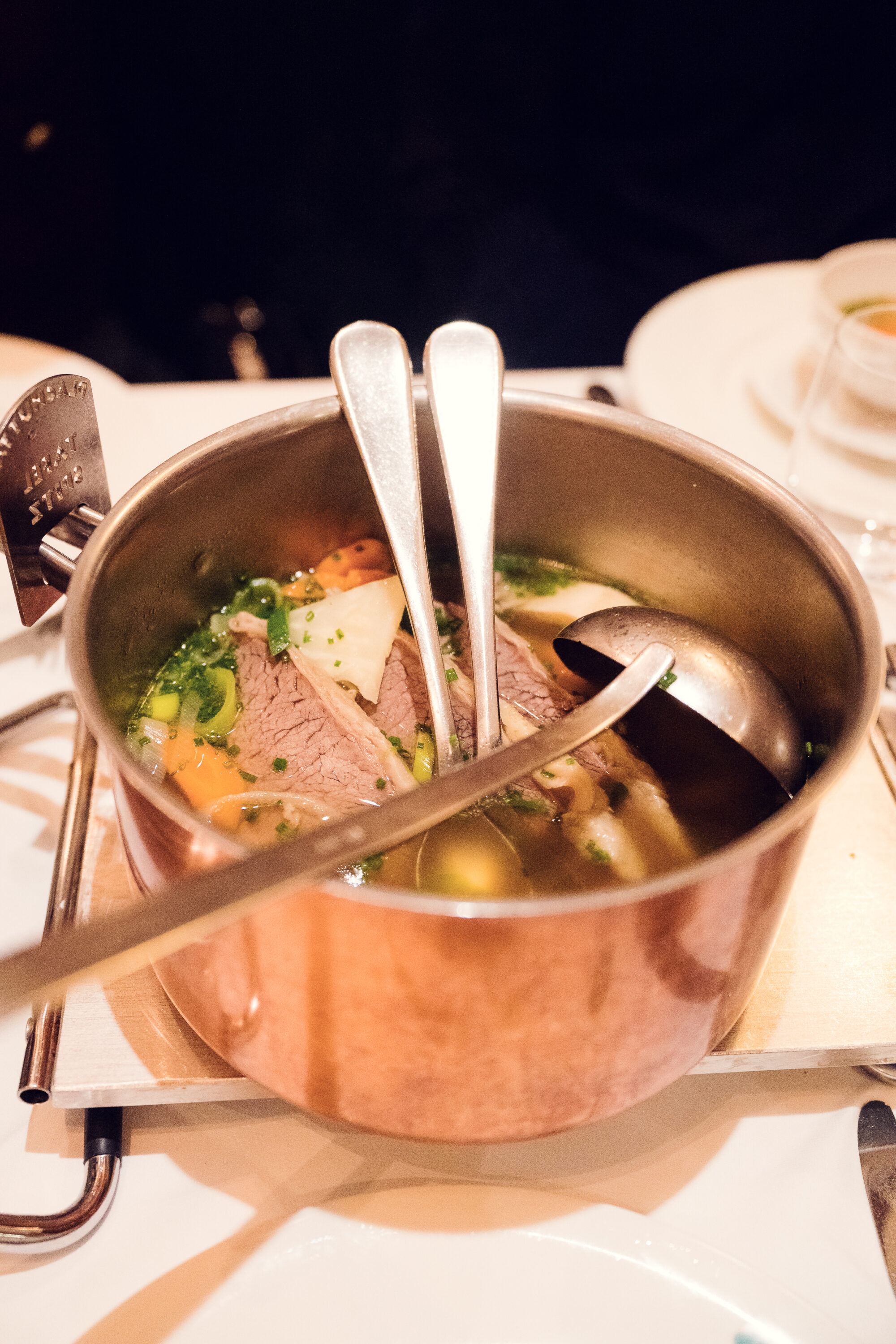 Bouillon doré avec légumes-racines, moelle et garniture d'herbes chez Plachutta.