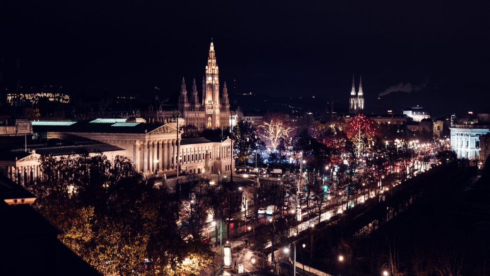 Il Municipio di Vienna illuminato di notte con le sue guglie che risplendono nel cielo scuro lungo la Ringstrasse.