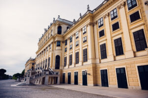 Seitenansicht von Schloss Schönbrunn, barocke kaiserliche Residenz mit gelber Fassade und klassischen Fenstern.