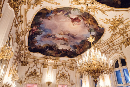 Historic ceiling painting at Schönbrunn Palace (Schloss Schönbrunn), baroque fresco artwork with allegorical figures and Austrian imperial symbols.
