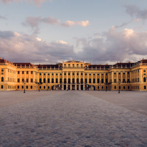 Außenansicht des Hauptgebäudes von Schloss Schönbrunn, barocker österreichischer Kaiserpalast mit den charakteristischen gelben Mauern.