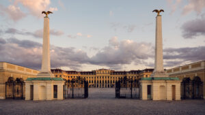 Historic entrance gate to Schönbrunn Palace, baroque Austrian imperial palace main entry with elaborate wrought iron gates and classical stone architecture.