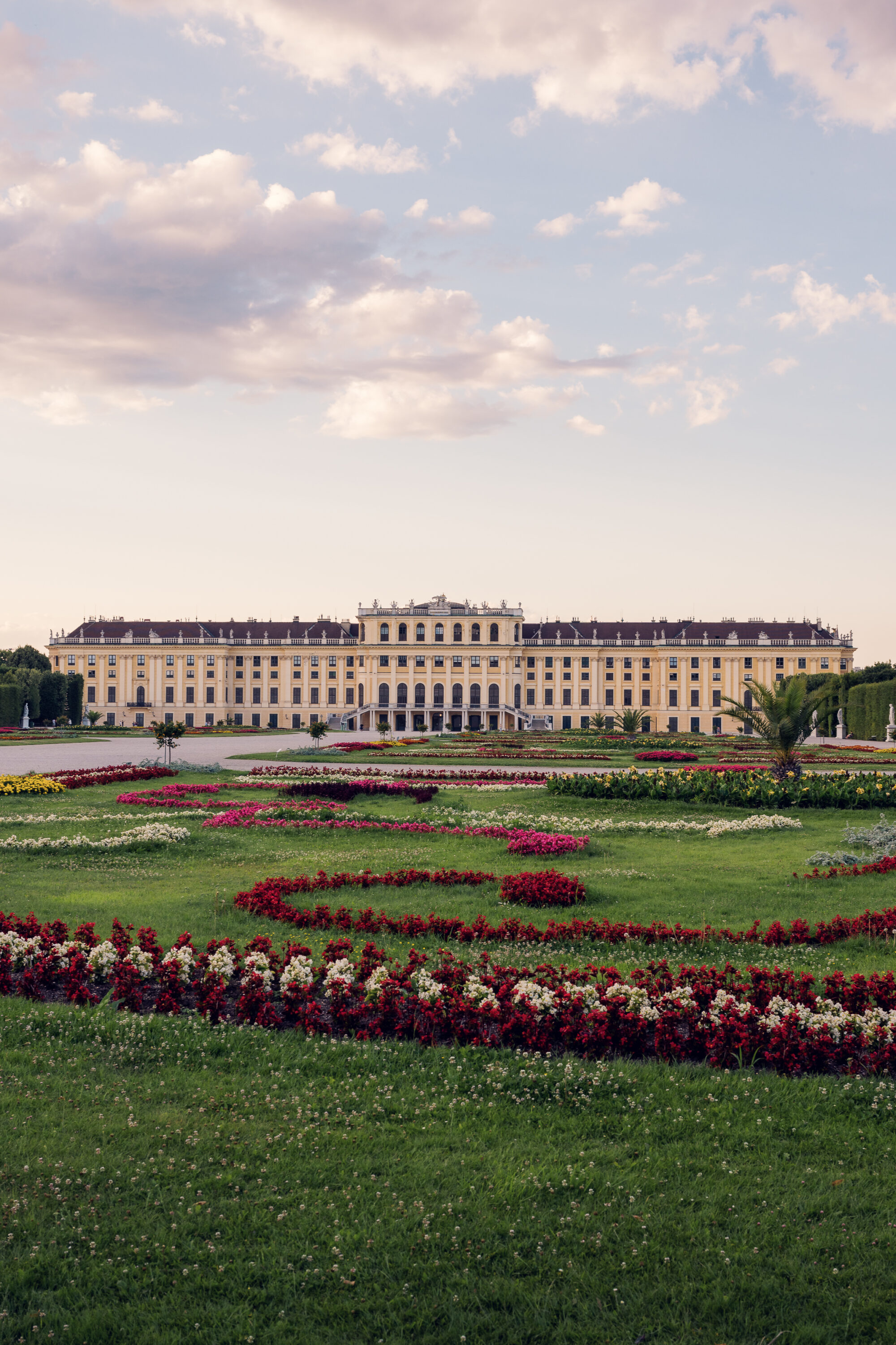 Schönbrunn Palace Schloss Schönbrunn baroque facade with colorful flower gardens in foreground.