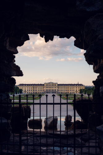 Neptun baroque fountain with mythological figures and palace view behind.