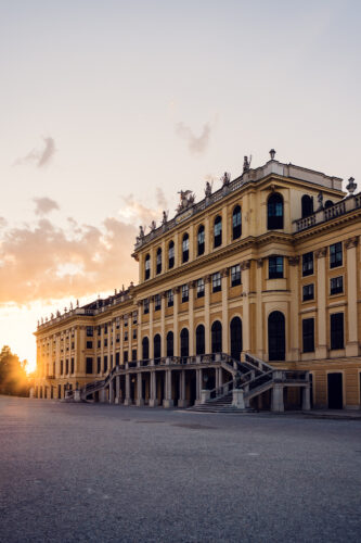 Schönbrunn Palace Schloss Schönbrunn baroque facade illuminated by golden sunset light.