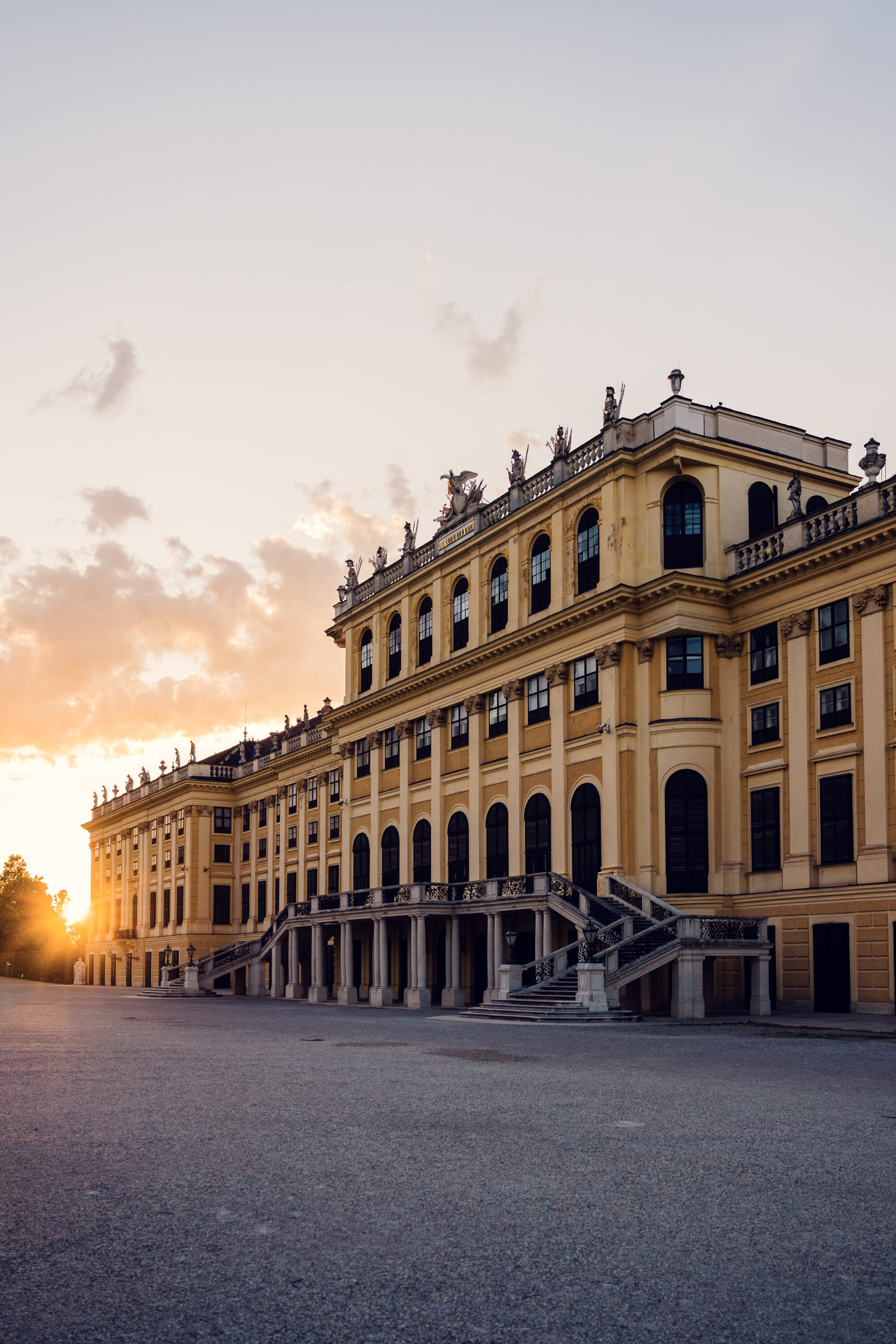 Schönbrunn Palace Schloss Schönbrunn baroque facade illuminated by golden sunset light.
