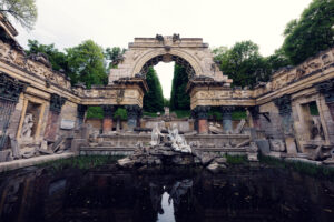 Rovine artificiali in stile romano con archi e paesaggio nel parco di Schönbrunn.