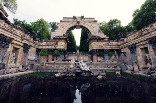 Rovine artificiali in stile romano con archi e paesaggio nel parco di Schönbrunn.