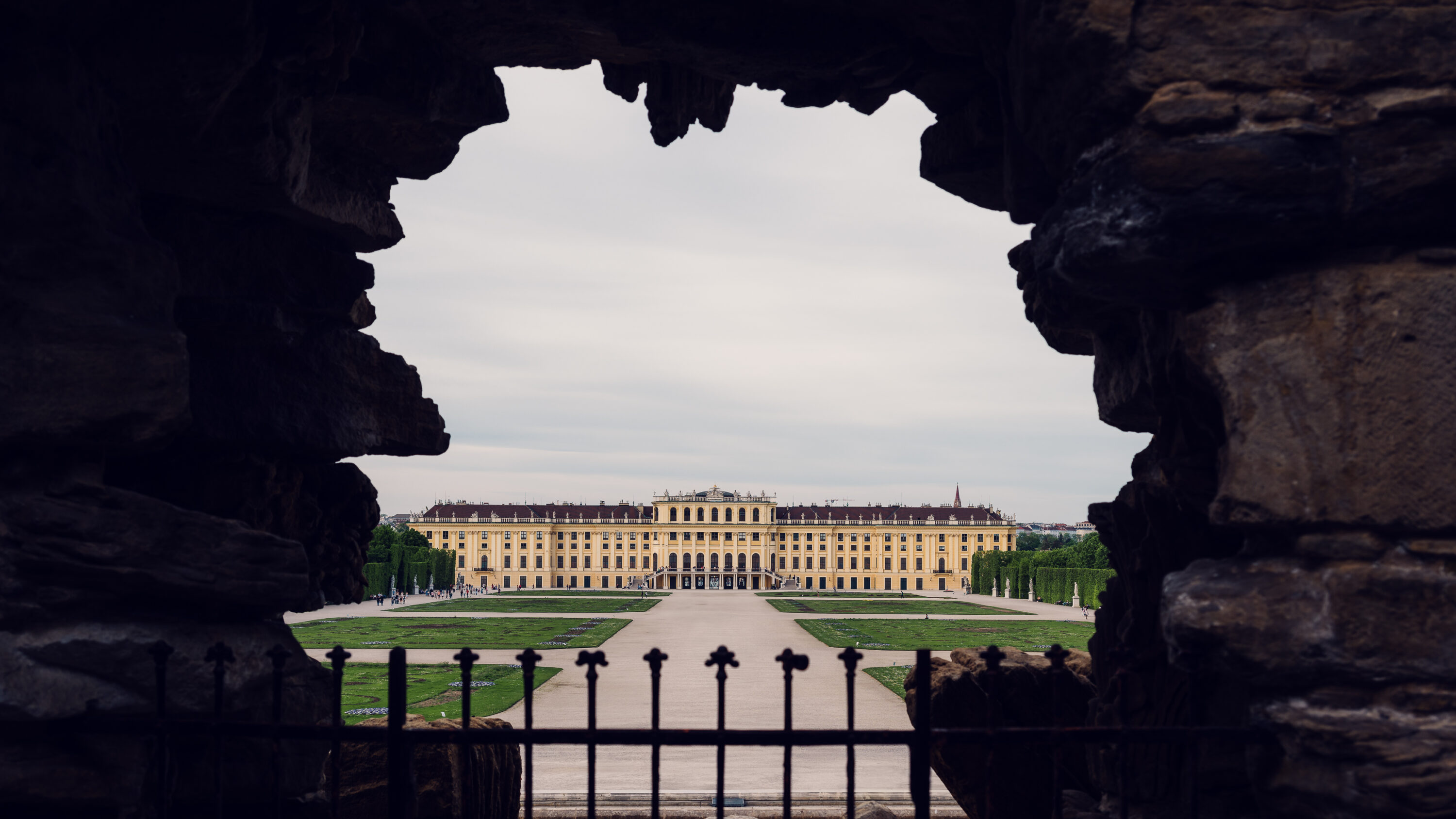 Neptun baroque fountain with mythological figures and palace view behind.