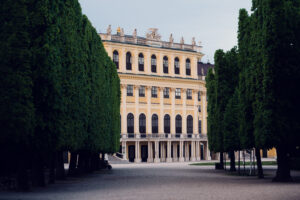 Viale alberato nel parco di Schönbrunn con vista sul palazzo.