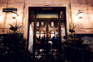 Rainy day view into Café Sacher Bel Étage, capturing the cozy interior from outside.