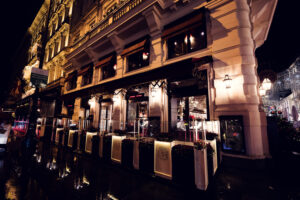 Moody view through the window of Café Sacher Bel Étage on a dark, rainy day.