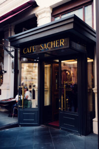 Entrance door to Café Sacher, leading guests into a world of culinary delights.