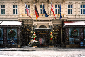 Hotel Sacher's grand entrance in the snow, capturing the charm of a Viennese winter.