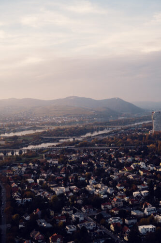View from the Donauturm toward Kahlenberg and the Danube River with bridges and residential neighborhoods below.