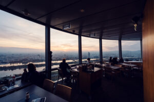 Donauturm Vienna rotating restaurant sunset through panoramic windows.
