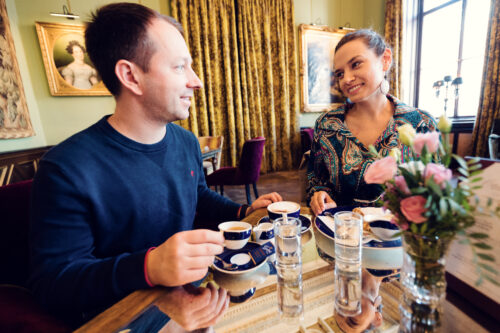 Couple enjoying coffee at Gerstner K. u. K. Hofzuckerbäcker, savoring the cozy atmosphere.