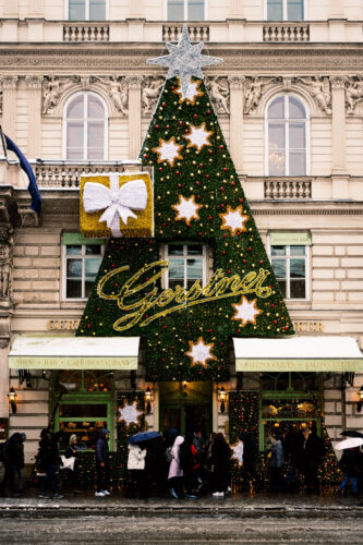 Gerstner K. u. K. Hofzuckerbäcker entrance in Vienna, adorned with festive decorations during winter.