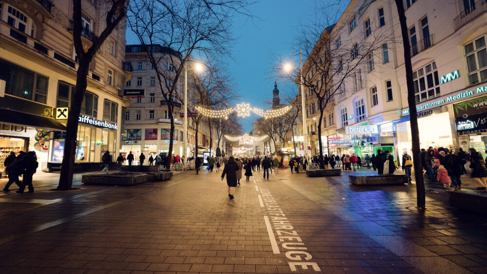 Mariahilfer Strasse Vienna Christmas crowd with holiday shoppers festive street atmosphere and seasonal decorations Austria's busiest shopping street.