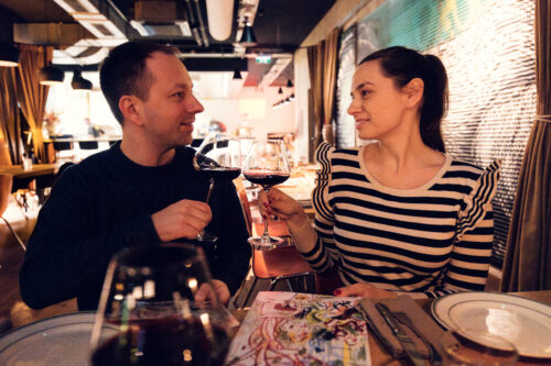 A couple cheering with wine at Neni am Prater, celebrating the lively dining atmosphere.
