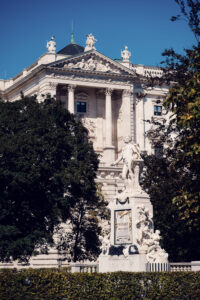 Monumento a Mozart en el Burggarten con la fachada de la Neue Burg al fondo.