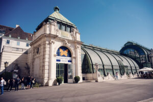 Entrance to the Schmetterlinghaus in Burggarten with the Art Nouveau glass roof of the Palmenhaus behind it.