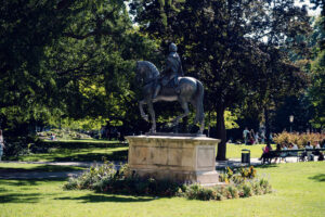 Estatua ecuestre del emperador Francisco I en el Burggarten, rodeada de parterres de flores y bancos a la sombra.