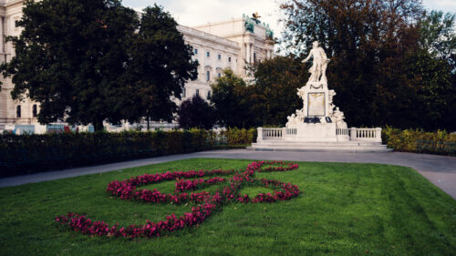 Mozart Monument surrounded by blooming flowers in Burggarten, a popular spot for music enthusiasts and tourists.