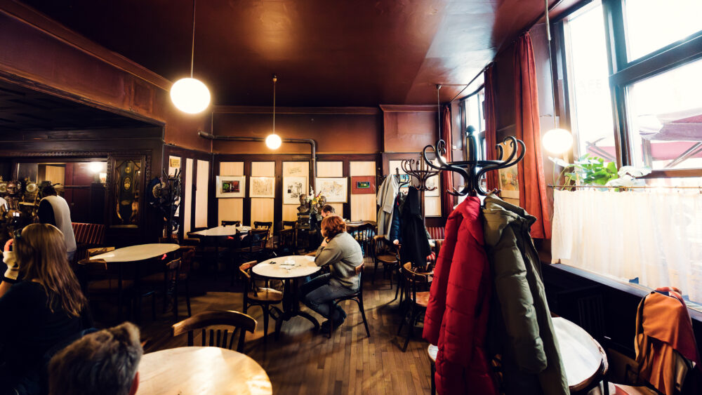 Time-worn interior of Café Hawelka, where smoke-darkened walls and original furnishings preserve authentic coffee house atmosphere.
