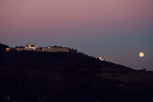 Enchanting view of Kahlenberg with the moon shining above, as seen from Cobenzl.
