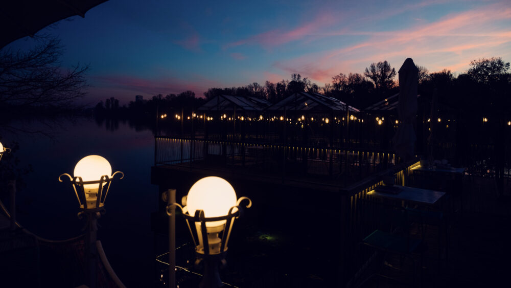 Golden hour magic at Das Bootshaus, where the setting sun transforms the Old Danube into a mirror of amber light.