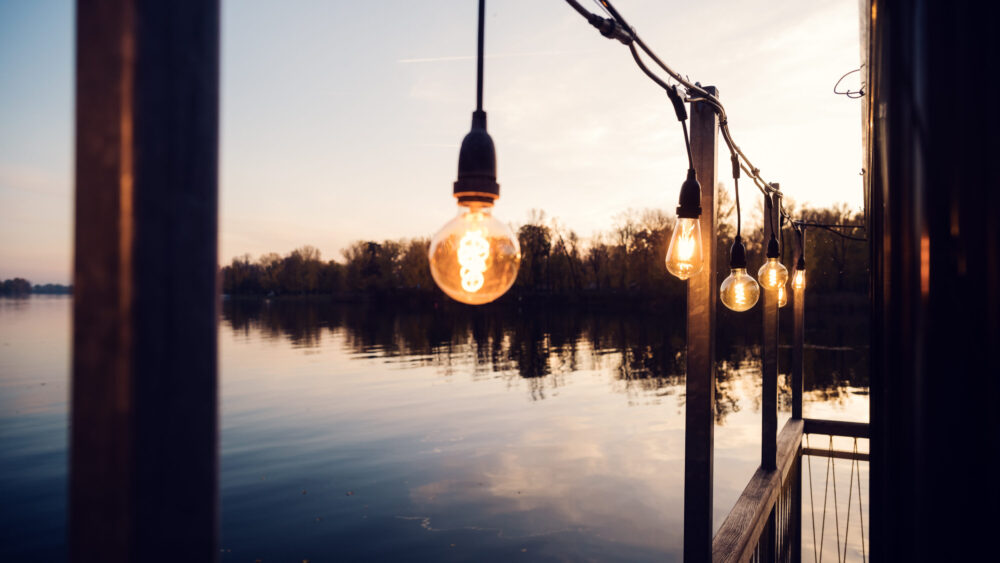 Evening transition at Das Bootshaus, when sunset colors paint the sky in dramatic hues above the Old Danube.