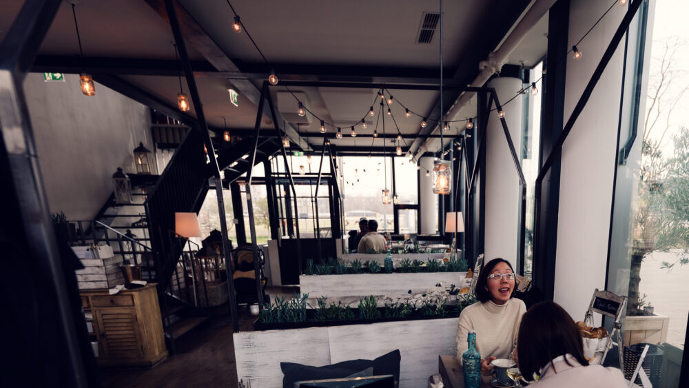 Morning atmosphere at Das Glashaus, where early light streams through glass panels creating magical shadows across breakfast tables.