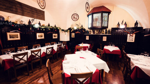 Cozy interior of Griechenbeisl, featuring original wooden beams and historic decor.