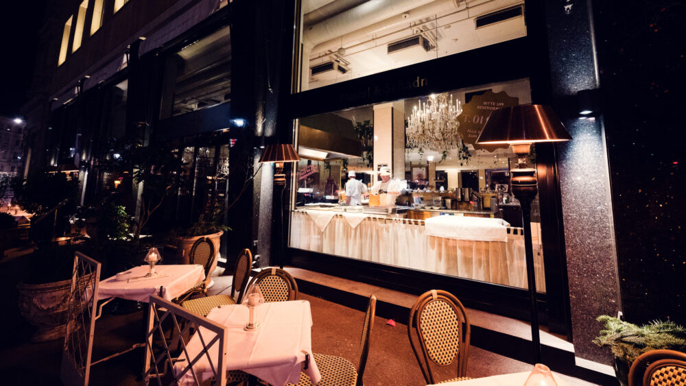 Meissl & Schadn's schnitzel show kitchen seen through the grand windows facing Ringstrasse.
