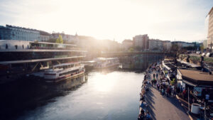 Curved white architecture of Motto am Fluss under a bright blue Viennese sky.