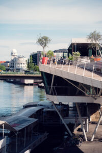 Motto am Fluss and its white silhouette reflected against the canal water.