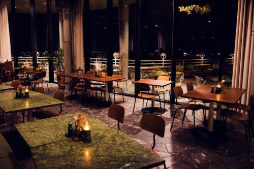 Mesa junto a la ventana en el Rondell Café con vista a las colinas de Viena.