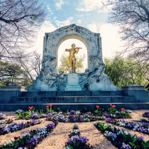Johann Strauss Monument surrounded by flowers in Stadtpark, a popular photo spot in Vienna.