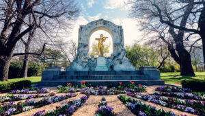 Johann Strauss Monument surrounded by flowers in Stadtpark, a popular photo spot in Vienna.
