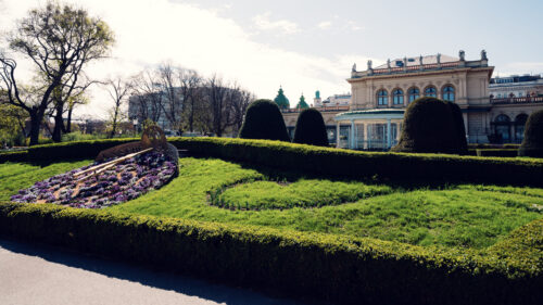 Spring blossoms framing tree-lined pathways in Vienna's Stadtpark.