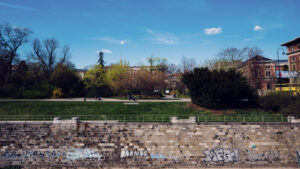 Wienfluss waterway through Stadtpark with original 19th-century stone embankments and bridges.